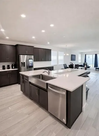 a kitchen with stainless steel appliances kitchen island granite countertop a sink and cabinets