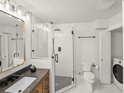 a bathroom with a granite countertop sink toilet and shower
