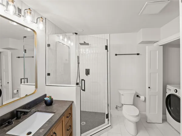 a bathroom with a granite countertop sink toilet and shower