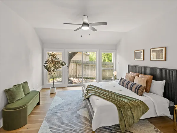 a spacious bedroom with a bed and glass walk in closet