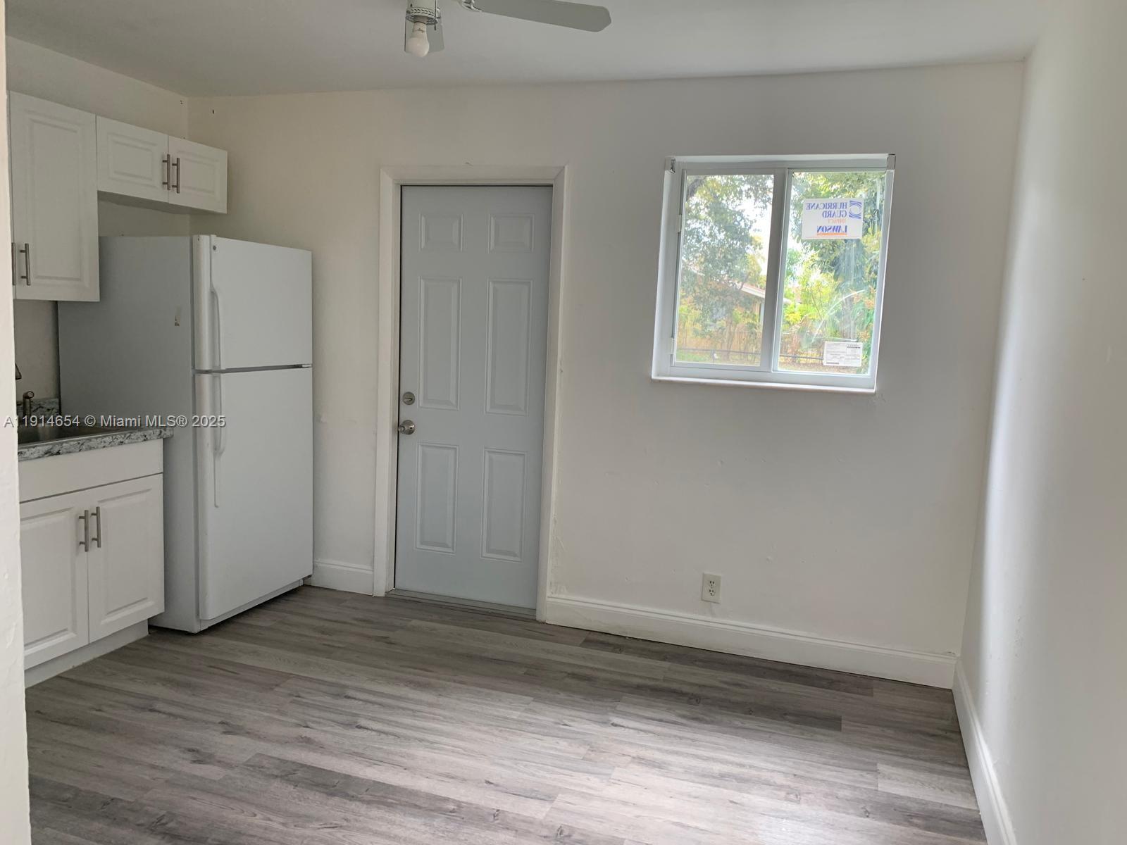 413 Northwest 4th Avenue, Unit 1 Hallandale Beach, FL 33009 - Photo 3 of 7 a view of a kitchen with wooden floor and electronic appliances
