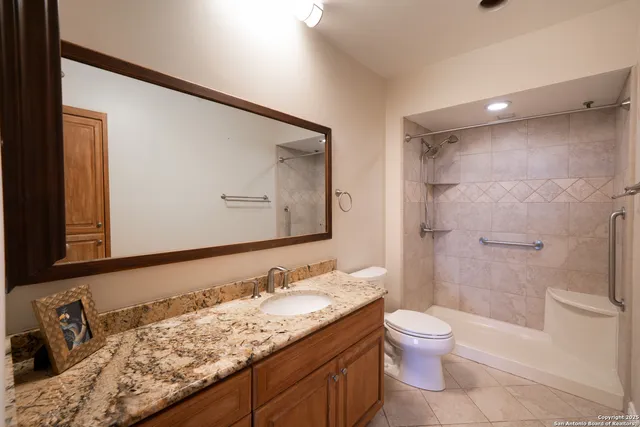 a bathroom with a granite countertop sink toilet and shower