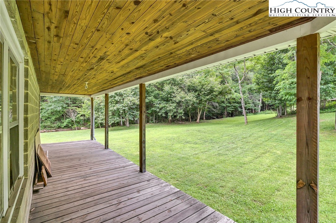 949 Coy Ham Road Lansing, NC 28643 - Photo 17 of 48 a view of a deck with a big yard potted plants and large tree