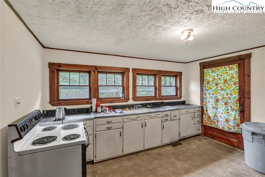 949 Coy Ham Road Lansing, NC 28643 - Photo 24 of 48 a kitchen that has a sink and a stove