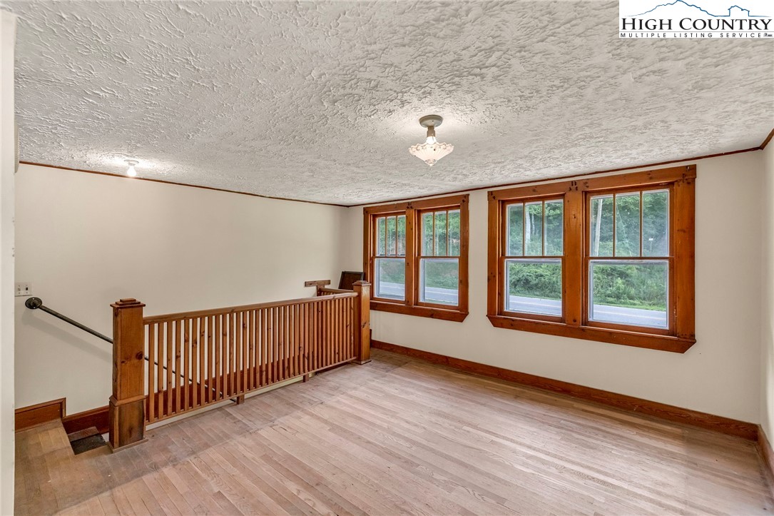 949 Coy Ham Road Lansing, NC 28643 - Photo 32 of 48 an empty room with wooden floor and windows