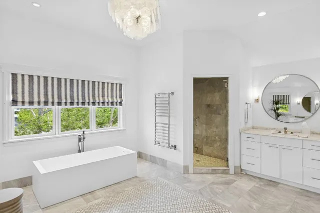 a living room with furniture a chandelier and a large window