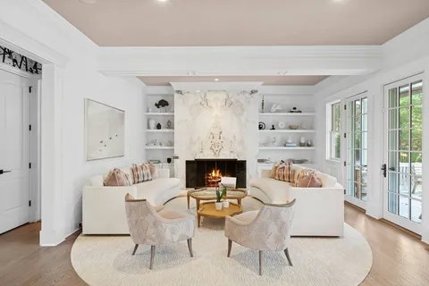 a living room with furniture fireplace and a large window