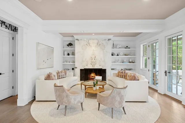 a living room with furniture fireplace and a large window