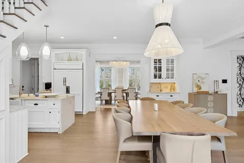 a large dining space with furniture a chandelier and wooden floor
