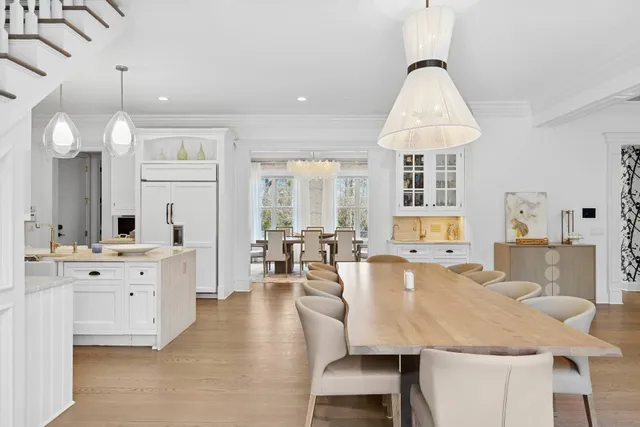 a large dining space with furniture a chandelier and wooden floor