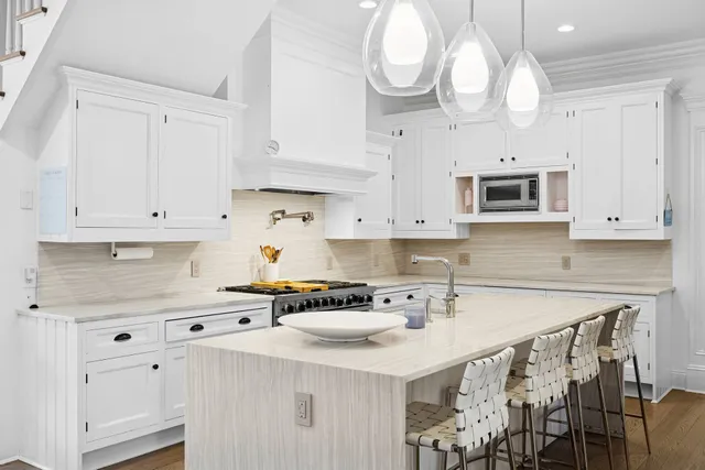 a kitchen with stainless steel appliances a sink a stove a microwave cabinets and a refrigerator