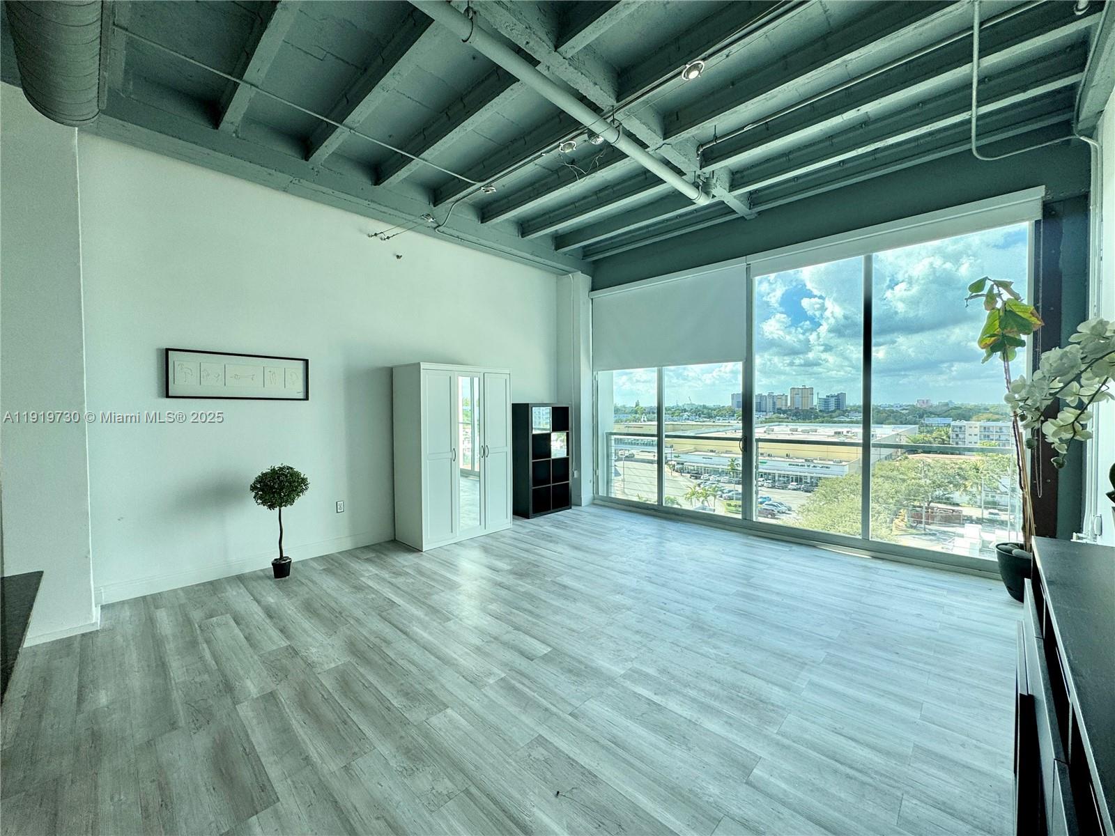 8101 Biscayne Boulevard, Unit R615 Miami, FL 33138 - Photo 12 of 27 a view of a room with wooden floor and windows