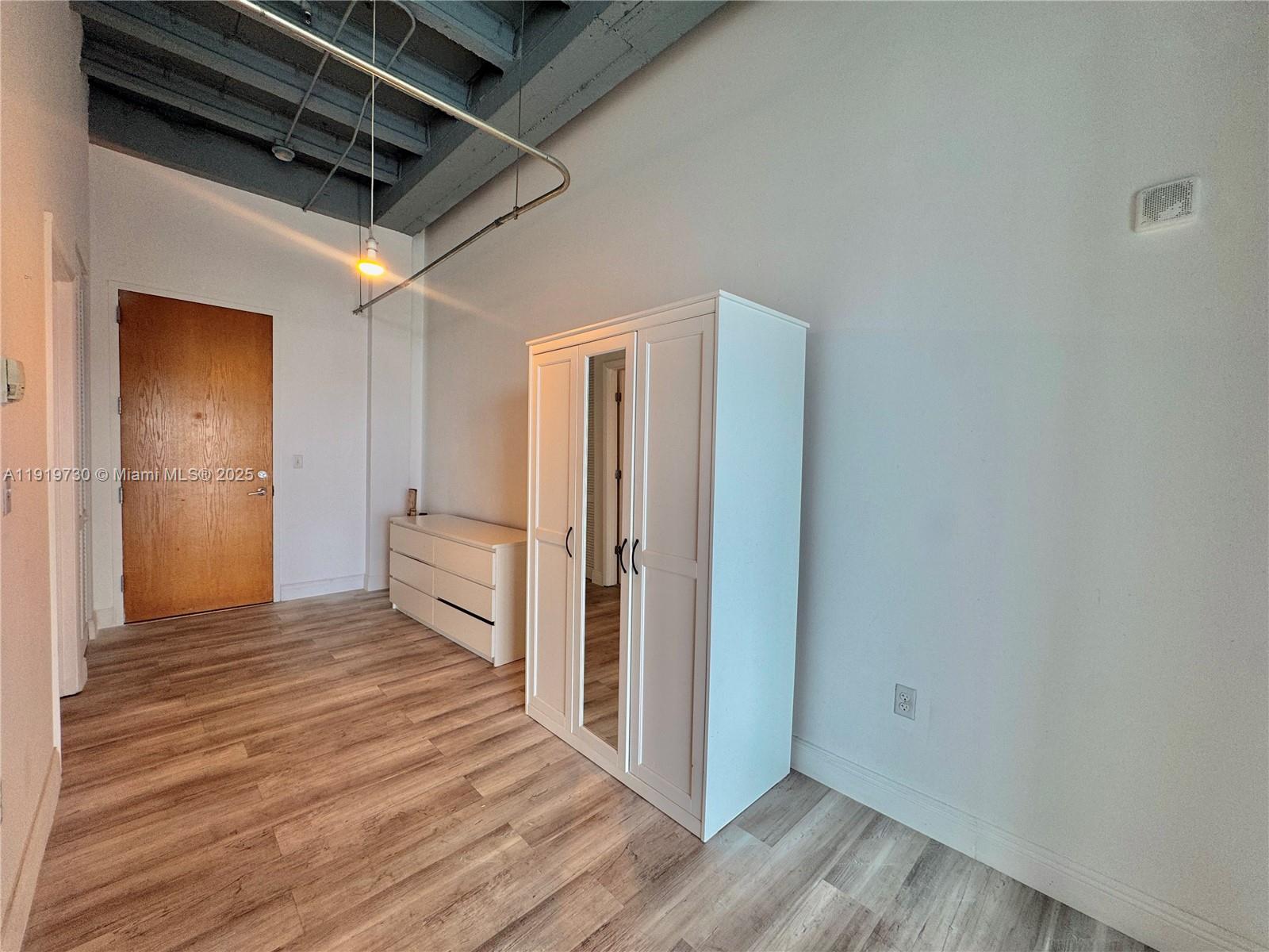 8101 Biscayne Boulevard, Unit R615 Miami, FL 33138 - Photo 15 of 27 a view of an empty room with wooden floor