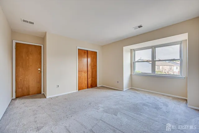an empty room with windows and closet