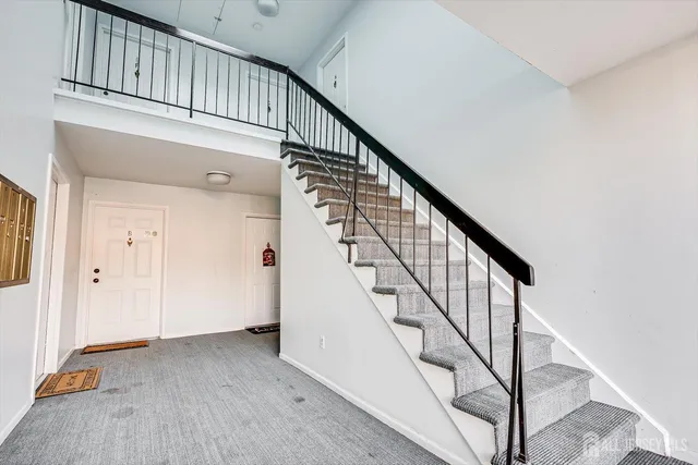 a view of staircase with railing and white walls