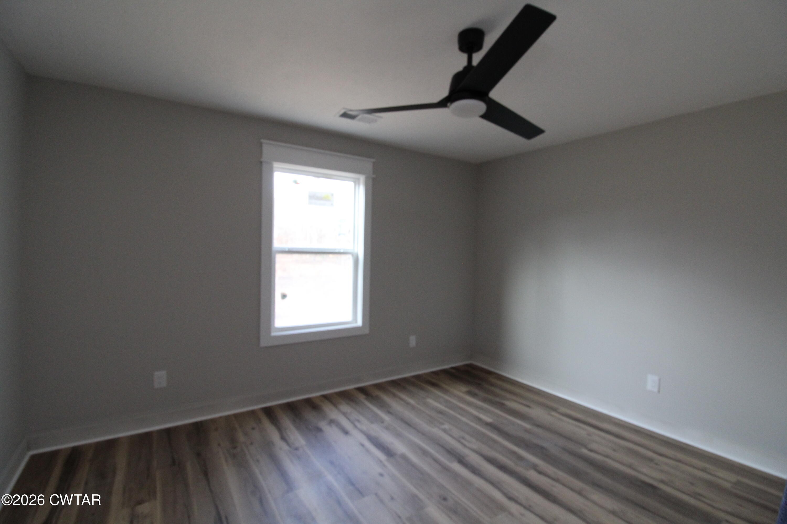 440 Oak Point Drive Lexington, TN 38351 - Photo 12 of 14 an empty room with wooden floor and windows