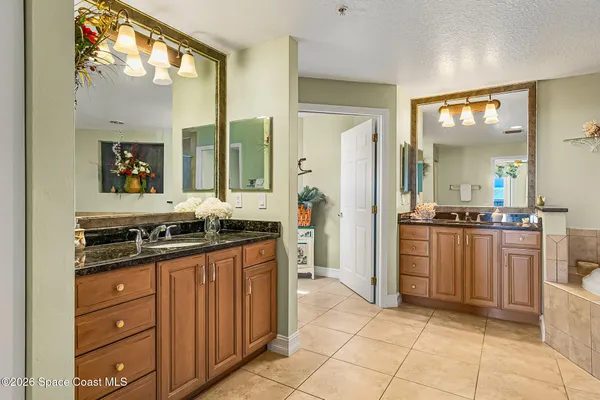 a bathroom with a granite countertop sink a toilet and a large mirror