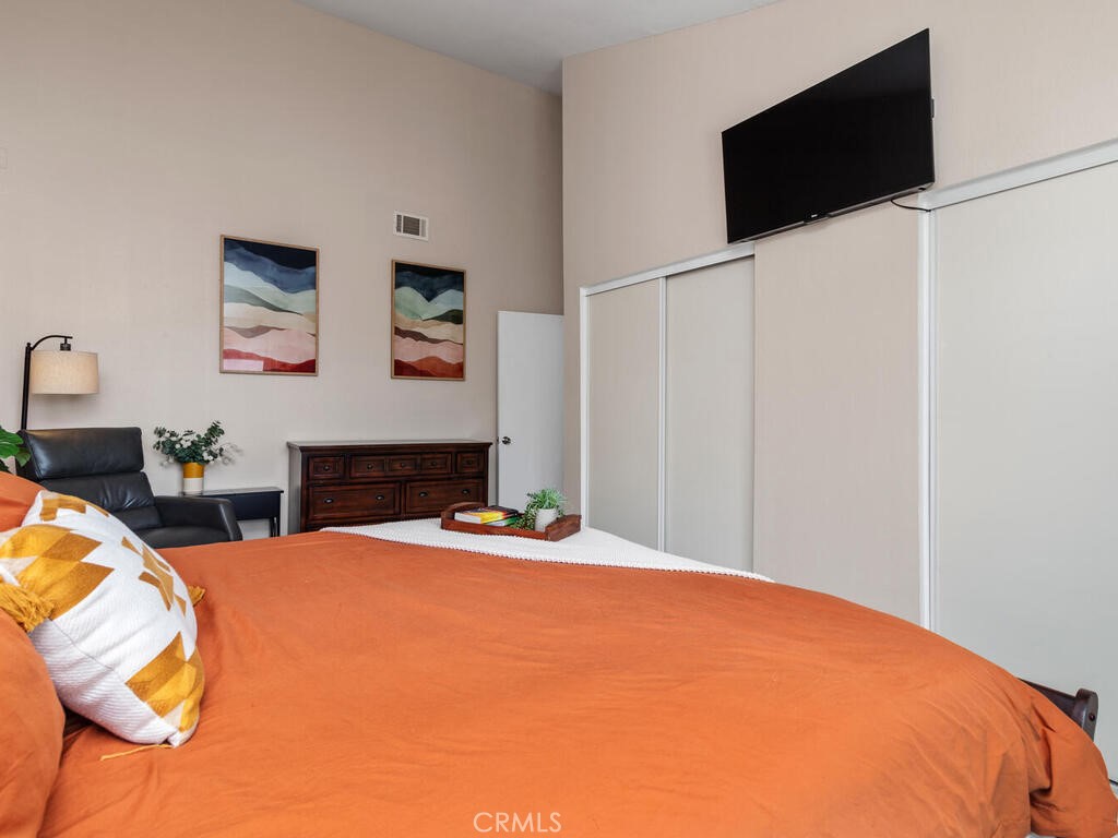 6907 Quail Place, Unit F Carlsbad, CA 92009 - Photo 18 of 24 a bedroom with a bed and a flat screen tv
