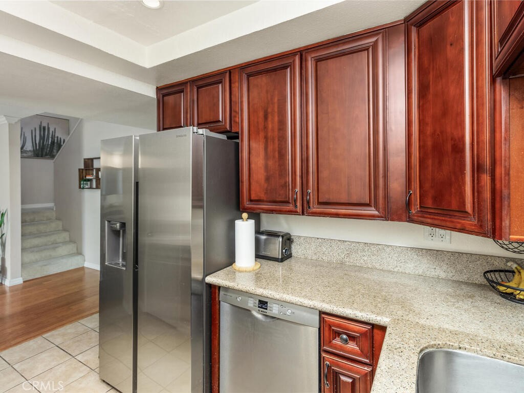 6907 Quail Place, Unit F Carlsbad, CA 92009 - Photo 6 of 24 a kitchen with stainless steel appliances granite countertop a refrigerator and a sink