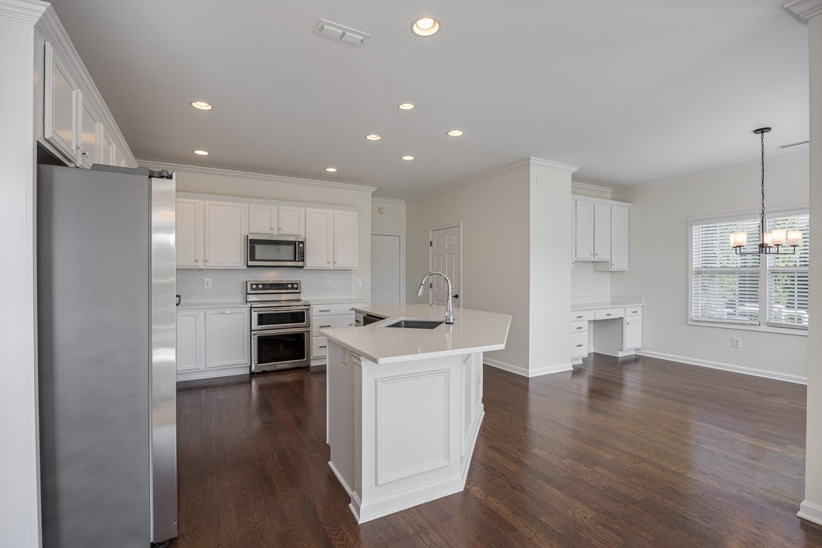 3002 Sakari Circle Spring Hill, TN 37174 - Photo 12 of 56 a kitchen with stainless steel appliances kitchen island wooden floors and white cabinets