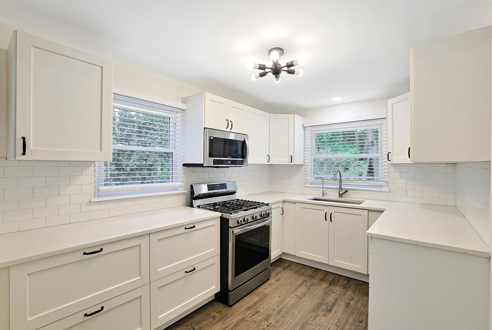 727 South Cook Street Barrington, IL 60010 - Photo 8 of 26 a kitchen with white cabinets stainless steel appliances a sink and a window