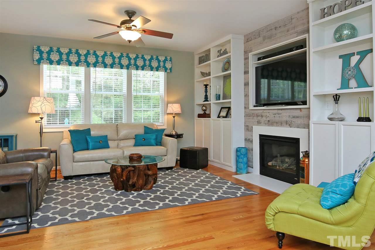 2525 Springfield Park Drive Raleigh, NC 27614 - Photo 3 of 25 Floor-to-ceiling built-in bookcases provide extra storage. Gas log fireplace with custom barnwood accent wall. All hardwood floors downstairs. True open concept living.