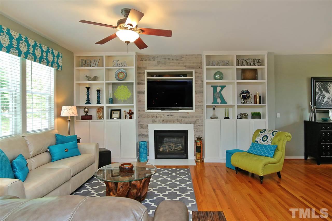 2525 Springfield Park Drive Raleigh, NC 27614 - Photo 4 of 25 Floor-to-ceiling built-in bookcases provide extra storage. Gas log fireplace with custom barnwood accent wall. All hardwood floors downstairs. True open concept living.