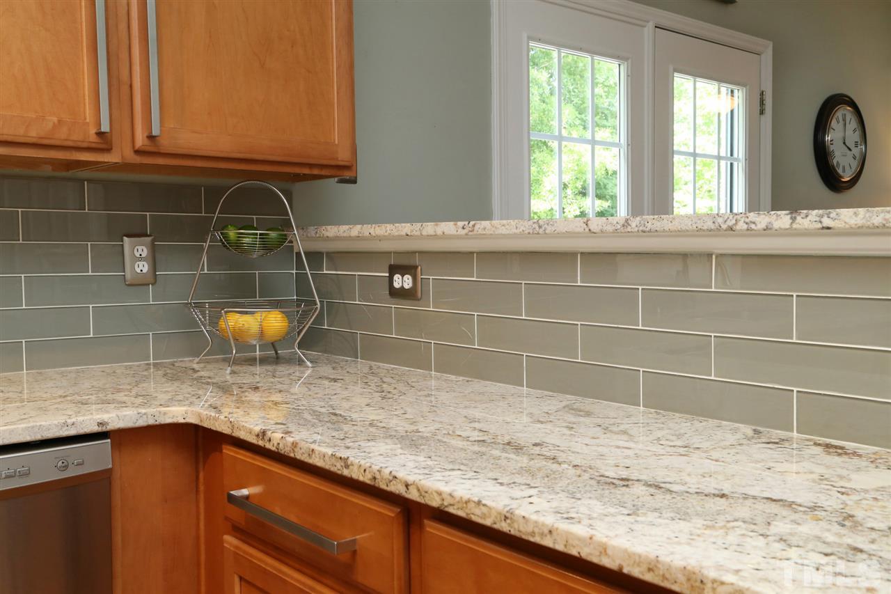 2525 Springfield Park Drive Raleigh, NC 27614 - Photo 9 of 25 Modern glass tile backsplash looks beautiful with high-end granite countertops.