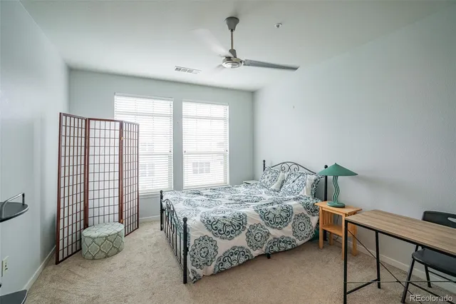 a bedroom with a bed table and chair
