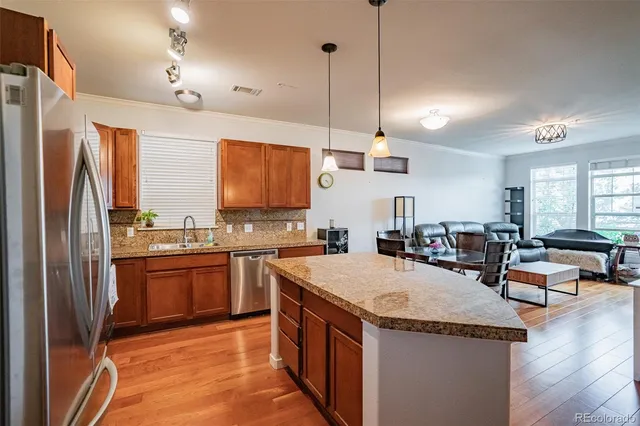 a kitchen with stainless steel appliances granite countertop a sink a stove and a refrigerator