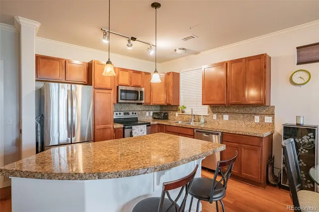 a kitchen with stainless steel appliances granite countertop a sink a stove and a refrigerator