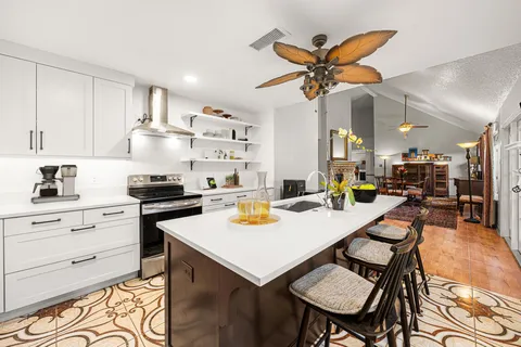 a kitchen with a table chairs and white cabinets