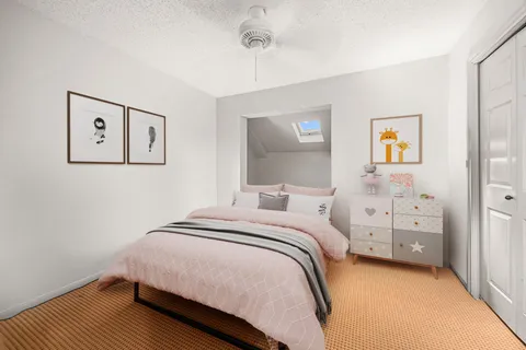 a bedroom with furniture a rug and a ceiling fan
