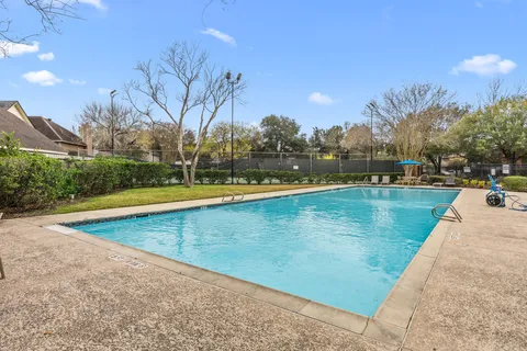 a view of a swimming pool and trees in the background