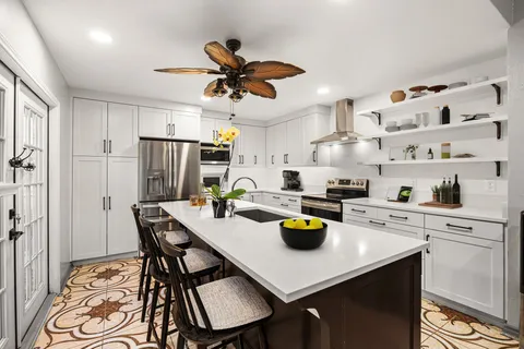 a kitchen with a dining table cabinets and stainless steel appliances