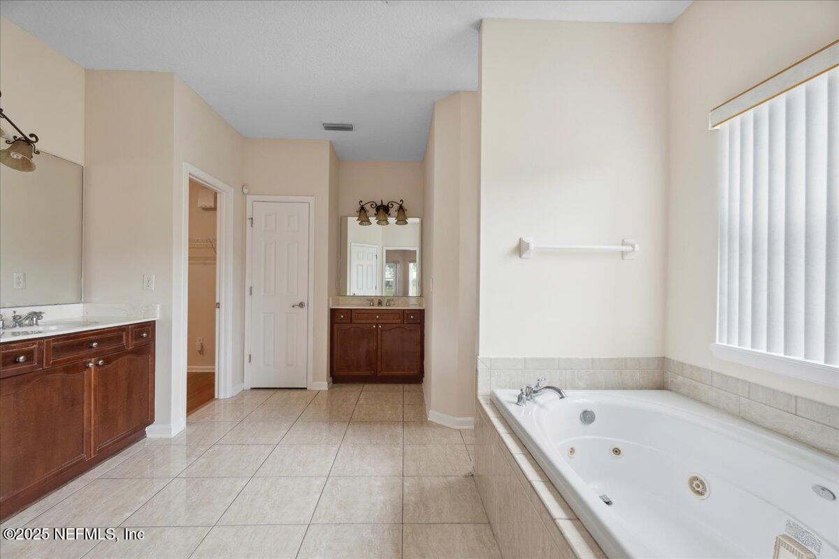 1127 Emilys Walk Lane West Jacksonville, FL 32221 - Photo 24 of 43 a bathroom with a tub a sink a mirror and a shower