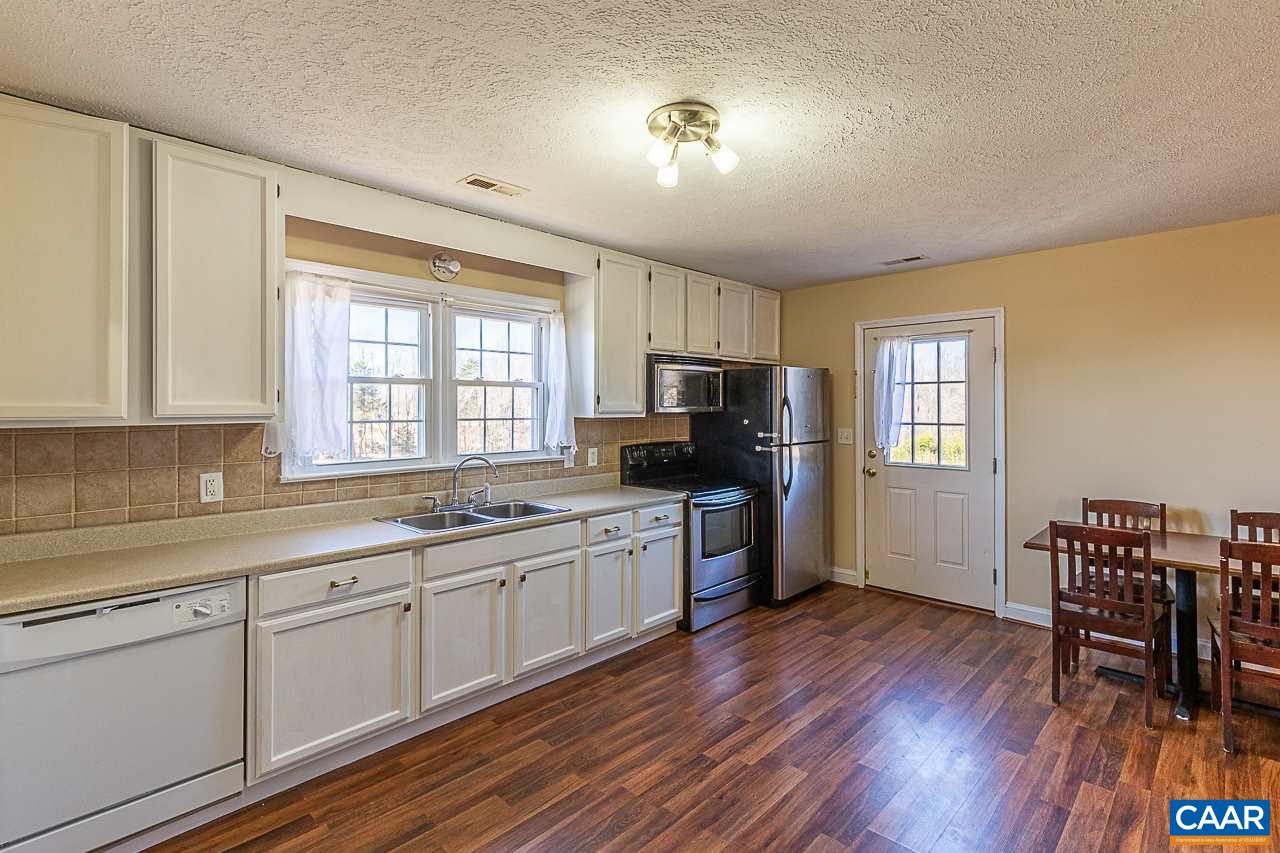 8031 Howardsville Road Howardsville, VA 24562 - Photo 19 of 30 a kitchen with sink cabinets and wooden floor