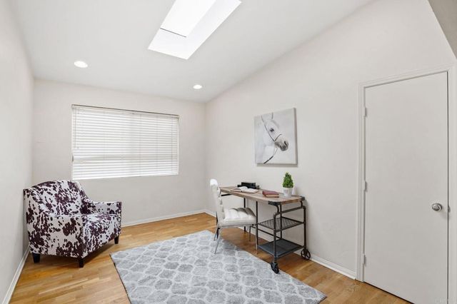 a living room with furniture kitchen view and wooden floor