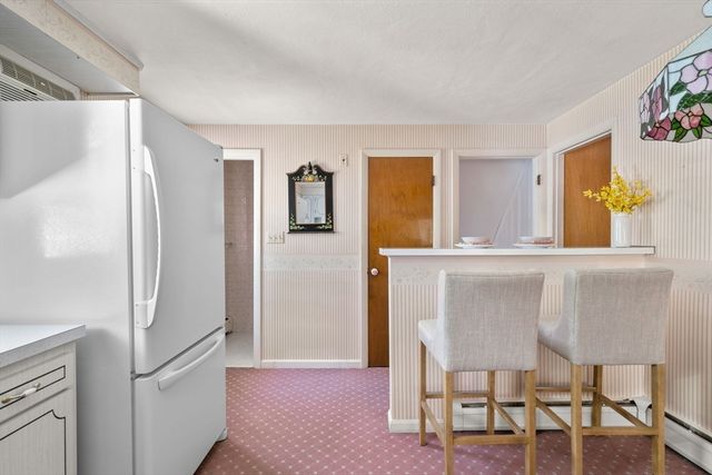 a kitchen with a refrigerator and table chair