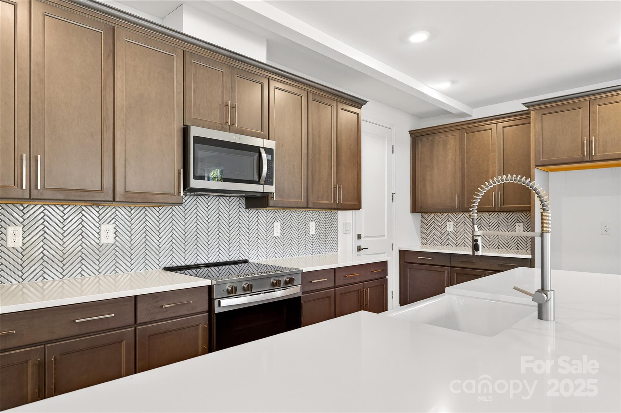 520 Zinc Drive Tega Cay, SC 29708 - Photo 3 of 20 a kitchen with stainless steel appliances granite countertop a sink stove and microwave