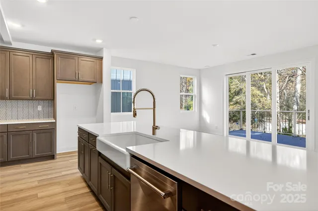 a kitchen with a sink and large windows