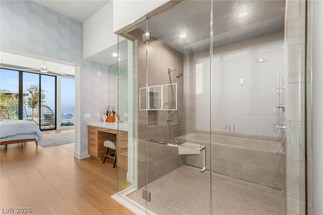 571 Overlook Rim Drive Henderson, NV 89012 - Photo 30 of 85 Full bathroom featuring ensuite bath, a stall shower, light wood-style flooring, and vanity
