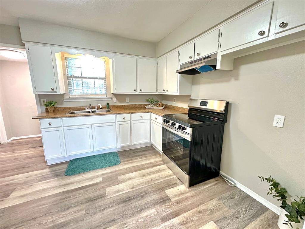 504 Bales Street Cleburne, TX 76033 - Photo 4 of 11 a kitchen with stainless steel appliances granite countertop a sink a stove and a refrigerator