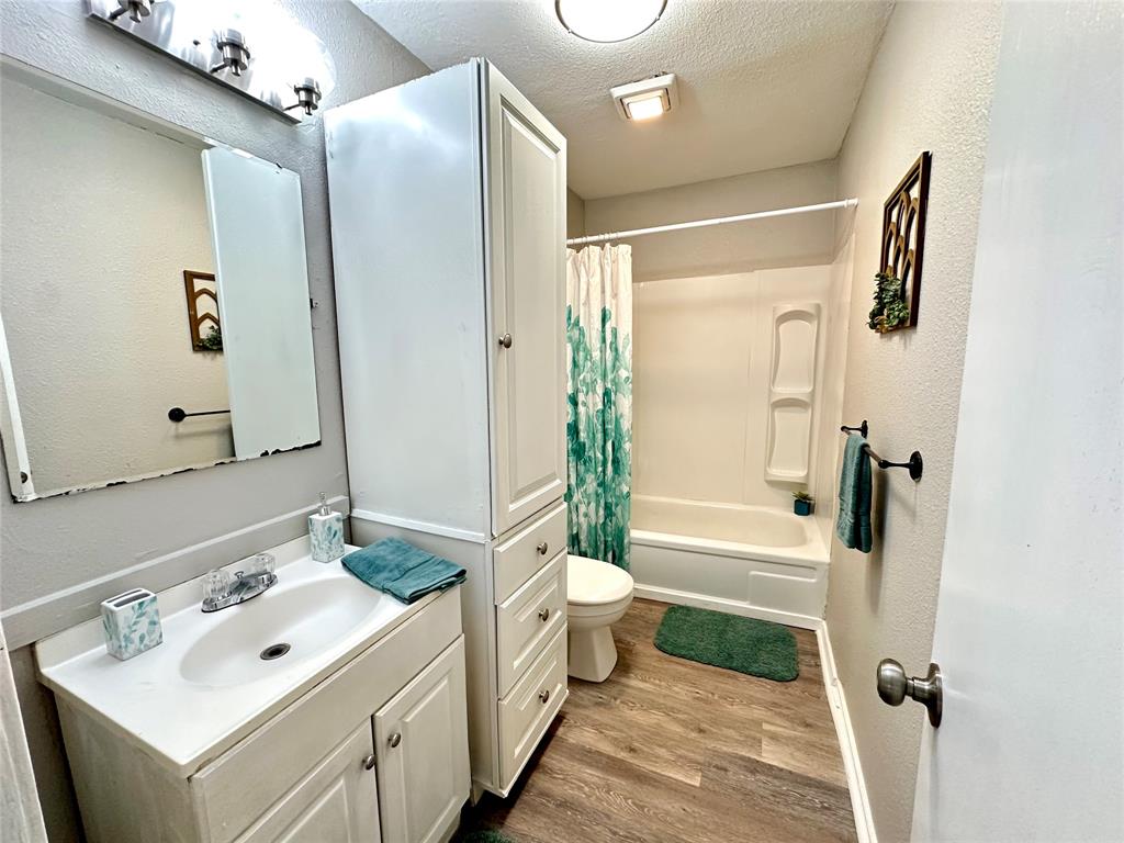 504 Bales Street Cleburne, TX 76033 - Photo 7 of 11 a bathroom with a sink mirror toilet and shower