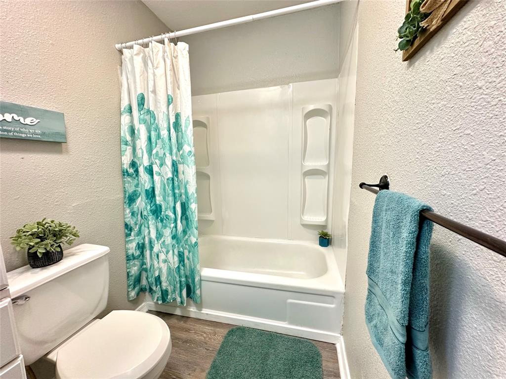 504 Bales Street Cleburne, TX 76033 - Photo 8 of 11 a bathroom with a toilet and a shower