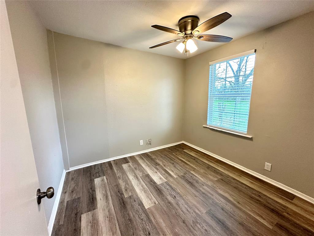 504 Bales Street Cleburne, TX 76033 - Photo 10 of 11 wooden floor in an empty room with a window