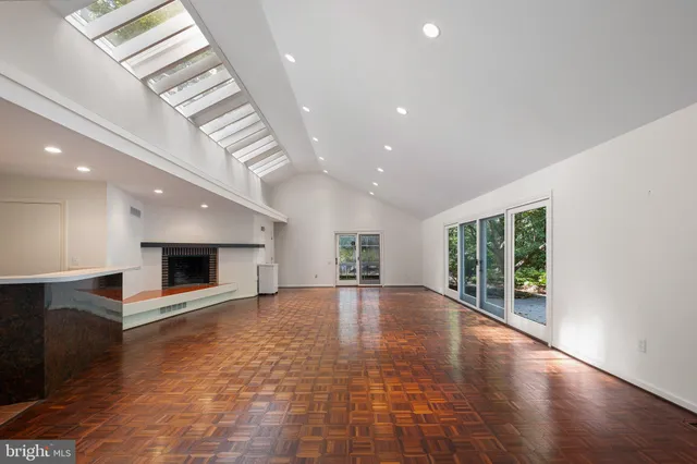an empty room with windows and fireplace
