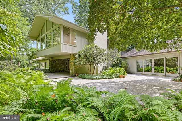 a front view of a house with a yard and potted plants