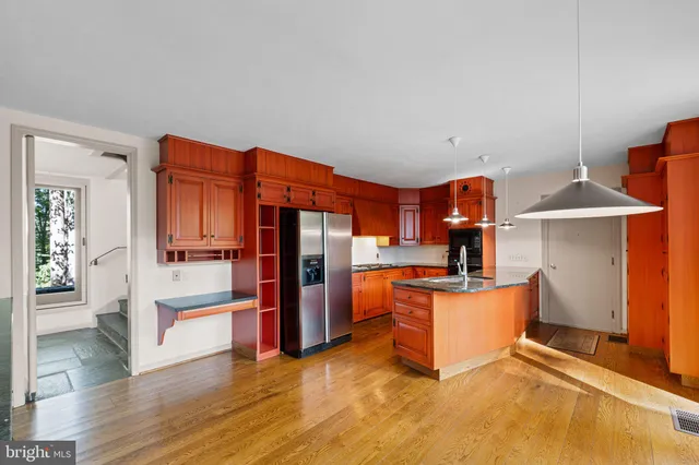 a living room with stainless steel appliances kitchen island furniture and wooden floor