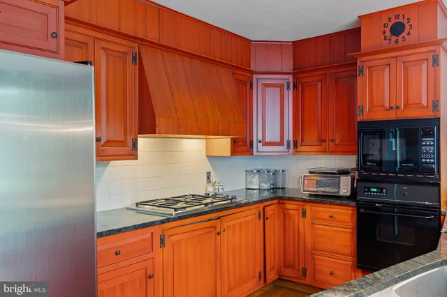 a kitchen with stainless steel appliances granite countertop a stove top oven a sink dishwasher and cabinets with wooden floor